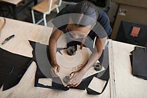 African female artisan working with leather in her studio