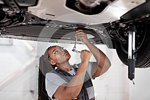 African Female auto mechanic work in garage, car service technician woman in overalls