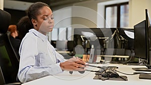 African female call center employee takes off her headset after work day.