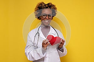 African female doctor holding a heart smiling