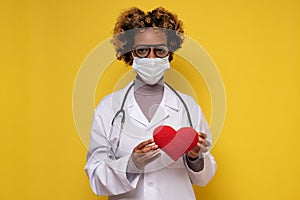 African female doctor holding a heart smiling