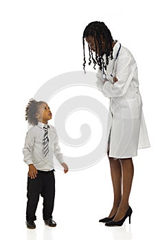 African female doctor and little boy is standing talking. Side view. Full length isolated