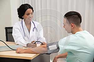 African female Doctor measuring Caucasian male patient blood with pressure Measuring.