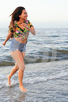 African female having fun walking by the sea - People and happiness concept