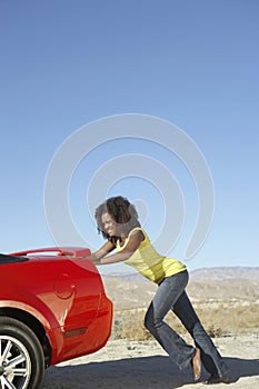 African Female Pushing Stopped Car