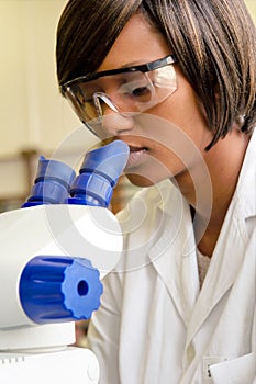 African female researcher looks into microscope