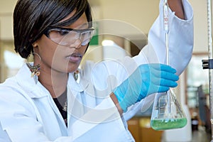 African female researcher works with a glass in the lab