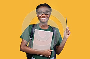 African Female Student Having Idea Pointing Pencil Up, Yellow Background