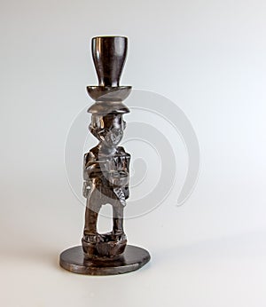 African figurine candlestick made of ebony on a white background