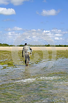 African fisherman leaving the beach with his fishing net