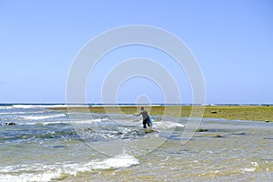 African fisherman in shallow water with his fishing net