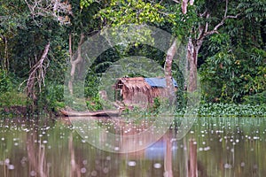 African forest hut reflected in water (Republic of the Congo)