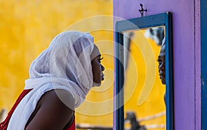 African Ghana woman standing in front of a mirror
