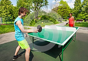 African girl and boy playing ping pong outside