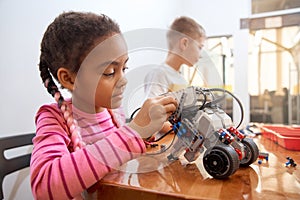 African girl creating robot.