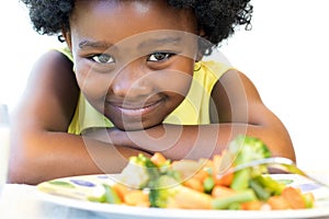 African girl in front of vegetable dish.