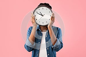 African Girl Holding Clock In Front Of Face, Pink Background