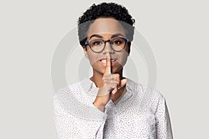 African girl holding finger on lips makes hush gesture