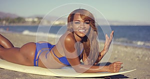 African Girl Lying on Surfboard While Sunbathing