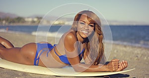 African Girl Lying on Surfboard While Sunbathing