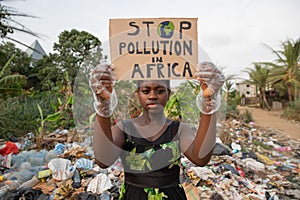 An African girl protests with a sign that says ``Stop pollution in Africa`, an activist for environmental rights in Africa