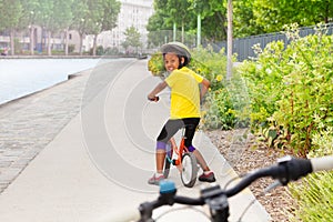 African girl riding bicycle on cycle lane in city