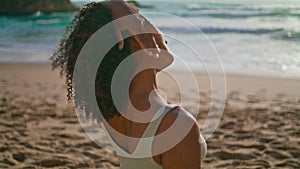 African girl stretching neck on sand beach close up. Woman warm-up at sunrise.