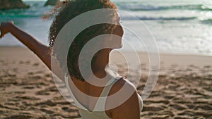 African girl stretching neck on sand beach close up. Woman warm-up at sunrise.