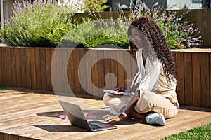 African girl student learning online using laptop studying outside campus.