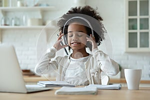 African girl wears headphones listen audio lesson learns school subject