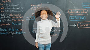 African girl writing and turn around to waving at camera at board. Erudition.