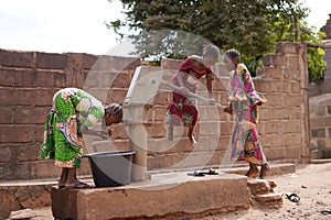 African Girls Having Trouble In Pumping Water Out Of An Almost Dry Public Well