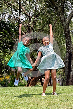 African girls jumping and shouting in garden