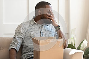 African guy feels stressed saw that goods in parcel damaged