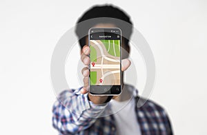 African Guy Showing Smartphone With GPS Navigator Over White Background