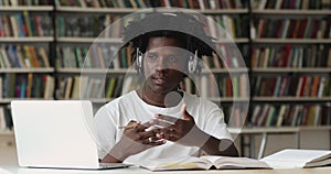 African guy studying, talks to tutor through video conference call