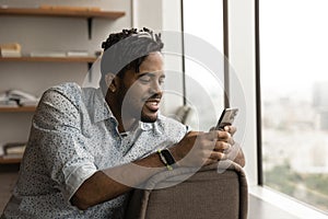 African guy take break at modern office using smartphone