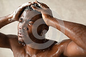 African Guy Washing Head With Eyes Closed Taking Shower Indoor