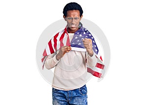 African handsome man holding united states flag annoyed and frustrated shouting with anger, yelling crazy with anger and hand