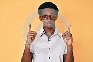 African handsome man pointing up with fingers depressed and worry for distress, crying angry and afraid