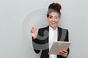 African happy business woman over grey wall