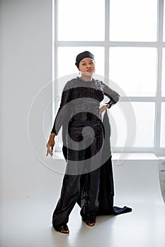 African islamic woman in black evening wear posing indoors