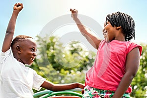 African kids looking at each other raising hands.