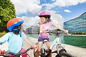 African kids riding bikes along a river embankment