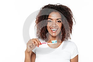 African lady holding toothbrush with toothpaste.