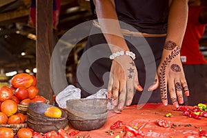 African lady showcasing the henna tattoo drawing on her hand in a local market.