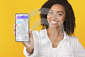 African Lady Showing Mobile Phone With Navigation App, Yellow Background