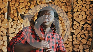 African lumberjack in the store with stacked logs for winter