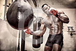 African male boxer punching ball wearing boxing