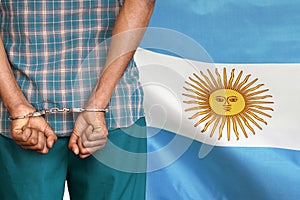 African male with handcuffs on the background of the Argentina flag